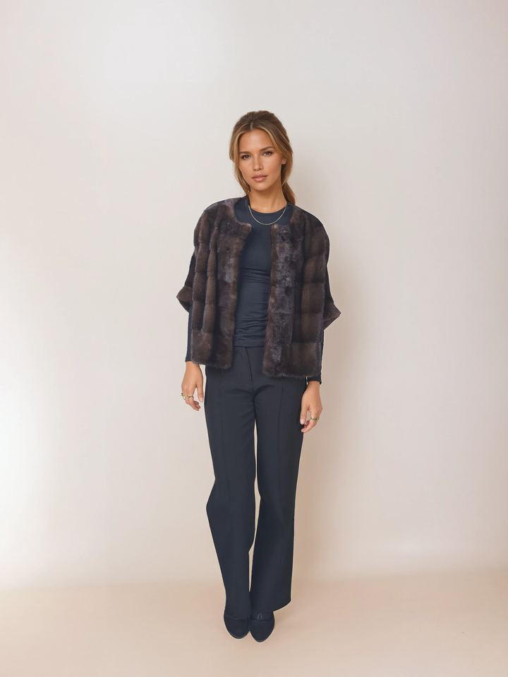Front view of a model wearing Tulle in brown mink over a navy top and trousers.